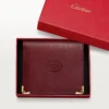 Flerfackig plånbok, Must De Cartier – vinrött kalvskinn, guldfärgad finish – Cartier Flerfackig plånbok, Must De Cartier – vinrött kalvskinn, guldfärgad finish – Cartier